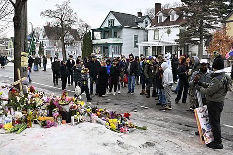 People gather around a makeshift memorial honoring the victim of a fatal shooting involving federal law enforcement agents, near the site of the shooting, Thursday, Jan. 8, 2026, in Minneapolis.