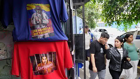 Pedestrians pass T-shirts featuring images of Venezuelan President Nicolas Maduro at a printing shop in Lima, Peru, Monday, Jan. 5, 2026, two days after US forces captured and removed him from Venezuela.