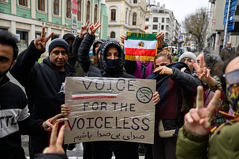 Anti-Iranian regime protesters hold a placard reading "Voice for the voiceless" and the flag of Iran from before the 1979 revolution, with the Lion and Sun emblems, during a demonstration outside the Iranian Consulate in Istanbul, on January 11, 2026.