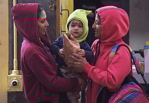 Women and child seen with warm sweater and caps , IMD as forecast cold wave conditions over most parts of interior Karnataka, some parts of Bengaluru on Saturday in Bengaluru.