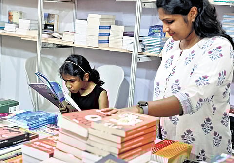 A young reader deeply engrossed in a book with her mother alongside at the Kerala Legislature International Book Festival, held on the assembly premises on
Sunday