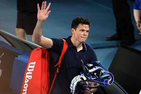 Milos Raonic of Canada waves as he leaves Rod Laver Arena after retiring from his first round match against Alex de Minaur of Australia at the Australian Open tennis championships.