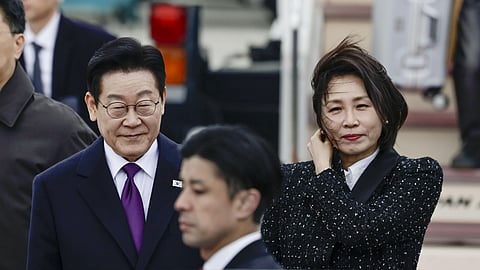 South Korean President Lee Jae Myung, left, and his wife Kim Hea Kyung, right, arrive at Kansai International Airport in Izumisano city, Osaka, western Japan, Tuesday, Jan. 13, 2026.