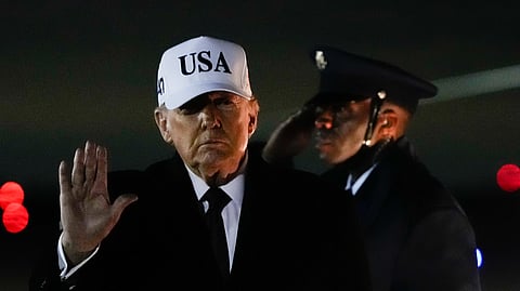 US President Donald Trump waves after arriving on Air Force One from Florida, Sunday, Jan. 11, 2026, at Joint Base Andrews, Md.