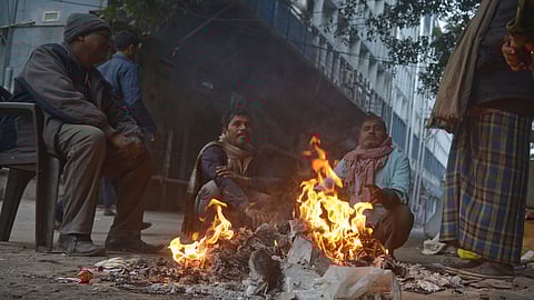 People trying to keep themselves warm by makeshift fire near I.T.O. on Monday.