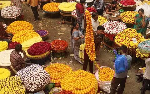 People buy flowers and other Puja materials at KR Market in Bengaluru