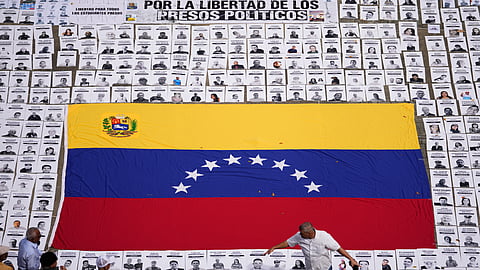 Activists lay out photos of people they consider political prisoners at the Central University of Venezuela in Caracas, Venezuela, Tuesday, Jan. 13, 2026.
