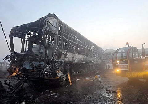 Cranes clear the charred remains of buses after a fog-hit pile-up involving several buses and cars triggered fires on the Yamuna Expressway, in Mathura, Tuesday, Dec. 16, 2025.