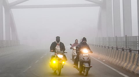 Commuters make their way during a cold and foggy winter morning, in Amritsar, Wednesday, Jan. 14, 2026.