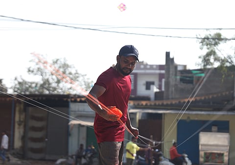 A man applies manja to a kite string, a traditional yet dangerous practice ahead of the Sankranti at Mangalhat in Hyderabad.