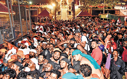 Devotees stand in reverence as they witness Makarajyothi at Lower Thirumuttam in Sabarimala on Wednesday.