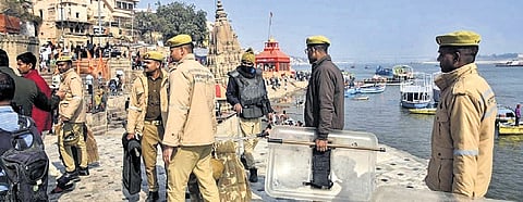 Police personnel stand guard at Manikarnika Ghat in Varanasi on Tuesday.