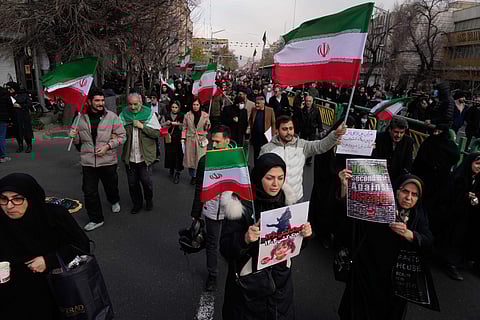 People carry Iranian flags and pro-government placards during a funeral ceremony for a group of security forces, who were killed during anti-government protests, in Tehran, Iran, Wednesday, Jan. 14, 2026.