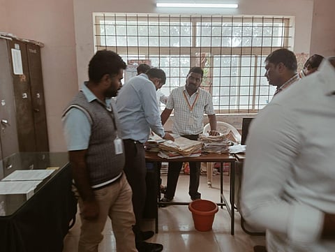 Lokayukta police personnel inspect documents during a raid at an office in Nagamangala taluk, Mandya district, on Wednesday