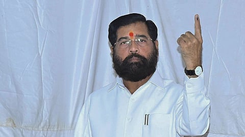Maharashtra Deputy Chief Minister Eknath Shinde displays his inked finger after voting