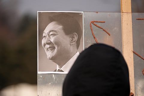 A picture of former South Korean President Yoon Suk Yeol is placed on a board as supporters gather outside Seoul Central District Court, in Seoul, South Korea, Friday, Jan. 16, 2026.
