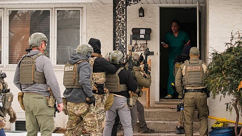 Teyana Gibson Brown, second from right, wife of Garrison Gibson, an immigrant, reacts after a federal immigration officer used a battering ram to break down a door before arresting Garrison Gibson, Sunday, Jan. 11, 2026, in Minneapolis.