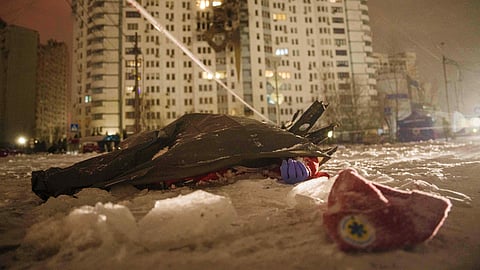 In this photo from Jan. 9, 2026, the dead body of a paramedic lies on the ground in front of a residential building damaged by a Russian strike on Kyiv, Ukraine.