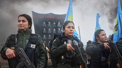 Female soldiers of the Kurdish-led, US-backed Syrian Democratic Forces (SDF) march during a military parade in Qamishli, northeastern Syria, Sunday, Jan. 18, 2026.