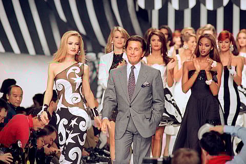 Italian fashion designer Valentino Garavani walks the catwalk with his models after a fashion show.