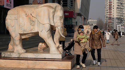 A woman lifts up a child in Beijing, China, on Jan. 15, 2026.