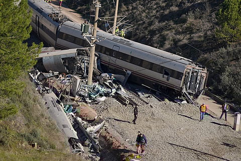 Guardia Civil officers collect evidence next to the wreckage of train cars involved in a collision in Adamuz, southern Spain, Tuesday, Jan. 20, 2026.