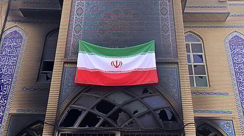 This photograph taken during a tour for foreign media shows an Iranian national flag installed on the Beheshti Mosque that was damaged during recent public protests in Tehran on January 21, 2026.