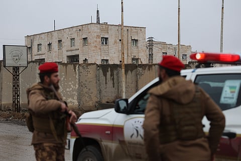 Syrian government forces stand guard at the al-Aqtan prison after taking control of it from the Kurdish-led Syrian Democratic Forces, SDF, in Raqqa, northeastern Syria, Friday, Jan. 23, 2026.