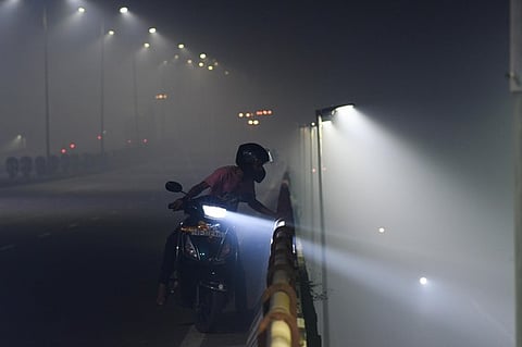 A motorist navigating his way through a smoggy evening