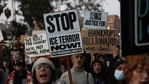 Demonstrators hold signs during a protest in response to the fatal shooting of 37-year-old Alex Pretti in Minneapolis earlier in the day Saturday, Jan. 24, 2026, in Los Angeles.