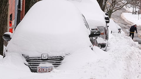 A man digs a car out of the snow on Beacon Hill following a winter storm that dumped more than a foot of snow across the region, Monday, Jan. 26, 2026, in Boston.