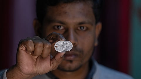 Maksudur Rahman, 31, who escaped after fighting for the Russian army, shows a Russian military dog tag during an interview with The Associated Press in Lakshmipur, Bangladesh, Dec. 10, 2025.