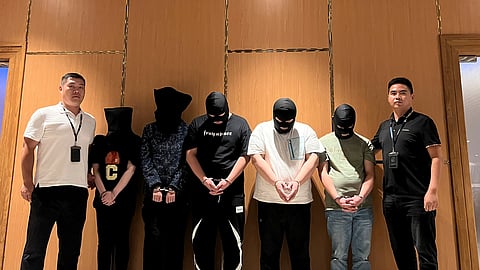 In this photo released by Xinhua News Agency, Myanmar police hand over five telecom and internet fraud suspects to Chinese police at Yangon International Airport in Yangon, Myanmar, Aug. 26, 2023.