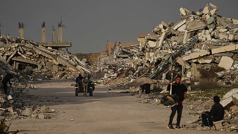 Palestinians walks amid the ruins left by the Israeli air and ground offensive in Zahra, central Gaza Strip, Wednesday, Jan. 28, 2026.