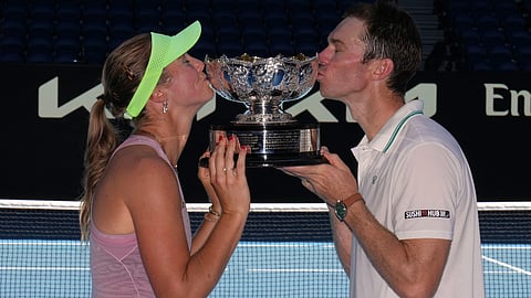 Australia's Olivia Gadecki and John Peers kiss their trophy after defeating France's Kristina Mladenovic and Manuel Guinard in the mixed doubles final at the Australian Open tennis championship in Melbourne.