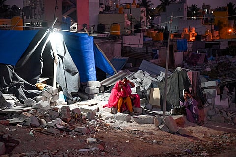 Women spend time by their makeshift home at Kogilu Layout. Their house was brought down after a demolition drive by GBA,