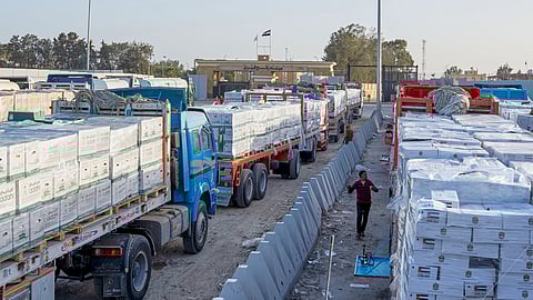 Trucks carrying humanitarian aids line up to enter the Egyptian gate of the Rafah crossing, heading for inspection by Israeli authorities before entering the Gaza Strip, in Rafah, Egypt, Sunday, Feb. 1, 2026.