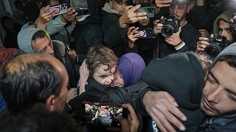 Najat Rubaie, center right, embraces one of her grandsons after they arrive with their mother as part of a group of about a dozen Palestinian returnees allowed into Gaza following the long-awaited reopening of the Rafah border crossing.