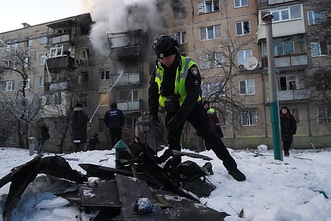 A police officer examines fragments of a Russian drone that hit an apartment block in Kharkiv, Ukraine, Tuesday, Feb. 3, 2026.
