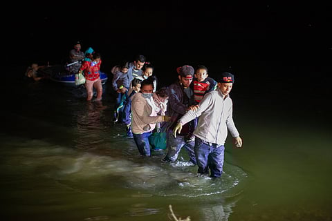 Migrant families wade through shallow waters toward Roma, Texas, March 24, 2021. (AP Photo/Dario Lopez