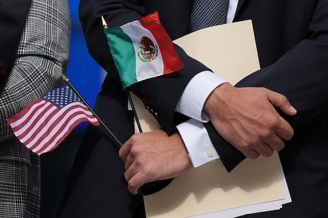 A person holds an American flag and a Mexico flag at a news conference, in Chicago, Sept. 4, 2025.