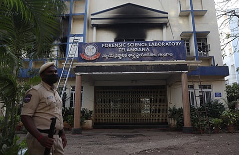 A police officer stands guard near the Telangana Forensic Science Laboratory after it was damaged in a fire accident.