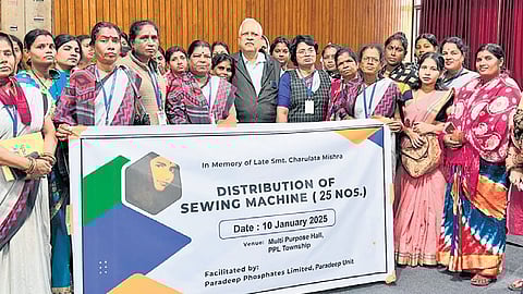 Hrushikesh Mishra poses with members of a women’s group after donating 25 sewing machines to them.
