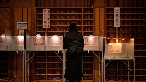 A voter fills in a ballot in the lower house election at a polling station Sunday, Feb. 8, 2026, in Tokyo.
