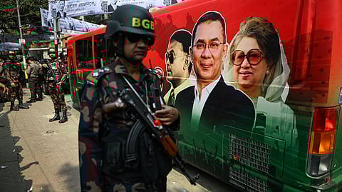 Security personnel stand guard next to a bullet proof bus of BNP chairman Tarique Rahman featured alongside his late parents, former prime minister Khaleda Zia and former president Ziaur Rahman, during a rally.