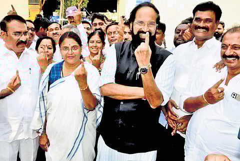 Irrigation Minister N Uttam Kumar Reddy shows his inked finger after casting his vote at a polling booth in the 14th ward of Kodad on Wednesday