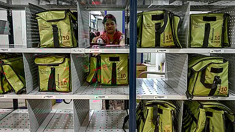 A rider arrives to collect a customer's order for delivery at a BigBasket dark store in Mumbai