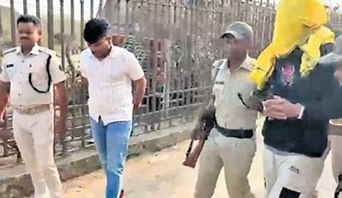 Police escort the apprehended fugitive.