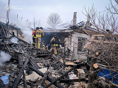 In this photo provided by the Ukrainian Emergency Service, a firefighter puts out the fire in private houses following a Russian air attack in Sumy region