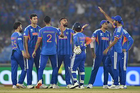 India's Varun Chakravarthy (C) celebrates with teammates after taking the wicket of Netherlands' Max O'Dowd during the 2026 ICC Men's T20 Cricket World Cup group stage match between India and Netherlands at the Narendra Modi Stadium in Ahmedabad.